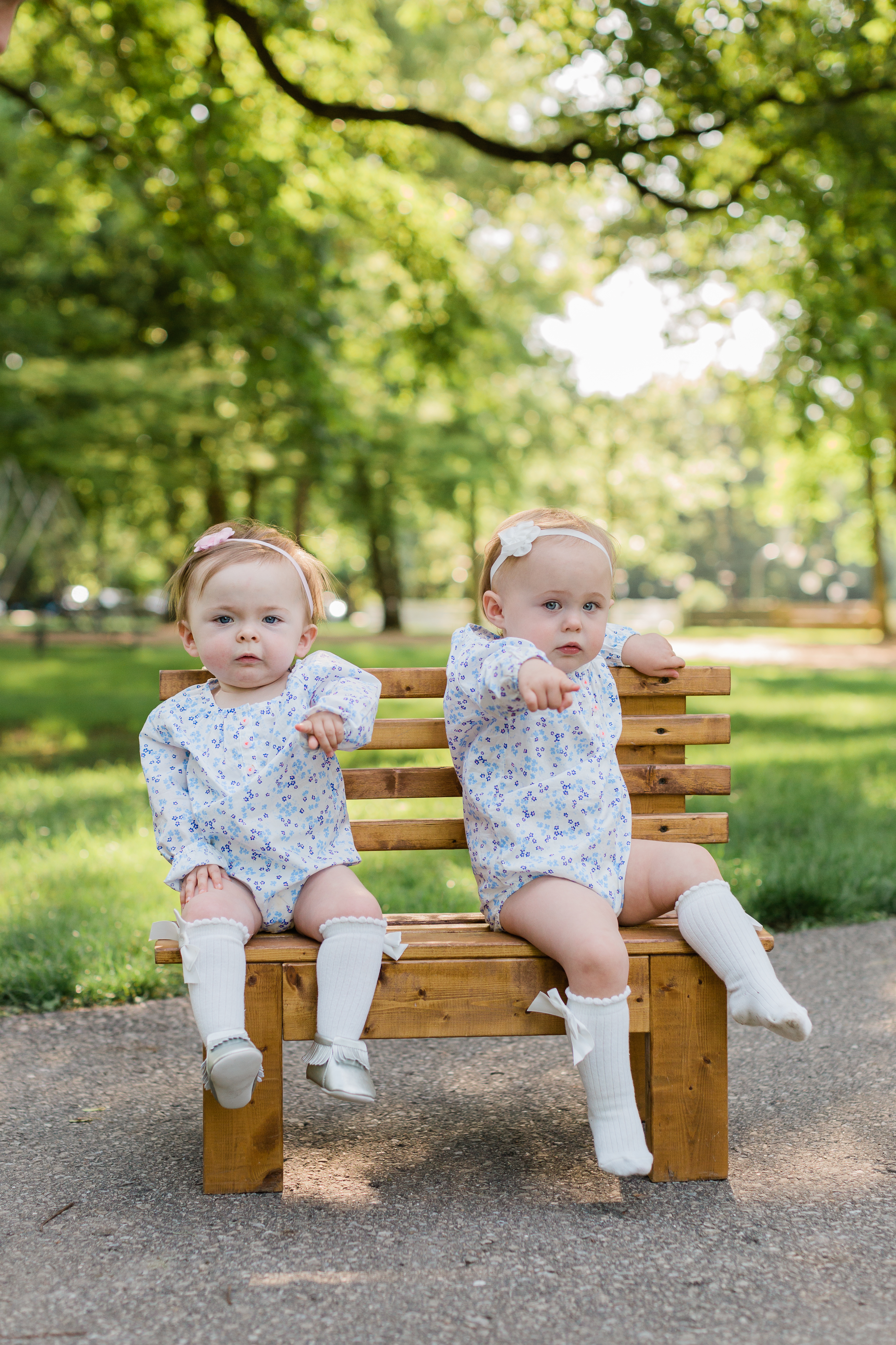 Twin girls dressed the same sitting on a small children's bench having their pictures taken by their mother, Jennifer Council