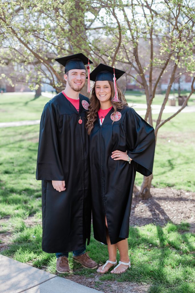 Young couple about to graduate college wearing their cap and gown having a picture taken together