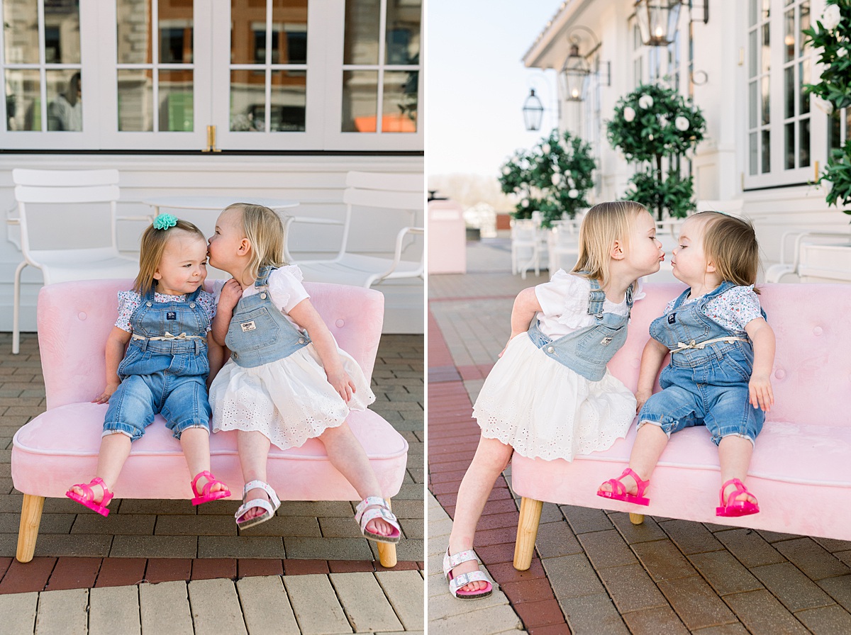 Twin two year old girls sitting on a little pink bench at Cake Bake Shop in Carmel, Indiana having family photos taken. 